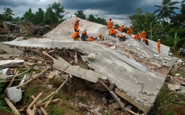 Rescue workers look for victims under the ruins of collapsed buildings in Cianjur on November 22, 2022, following a 5.6-magnitude earthquake that killed at least 268 people, with many hundreds injured and others missing. (Photo by TIMUR MATAHARI / AFP)
