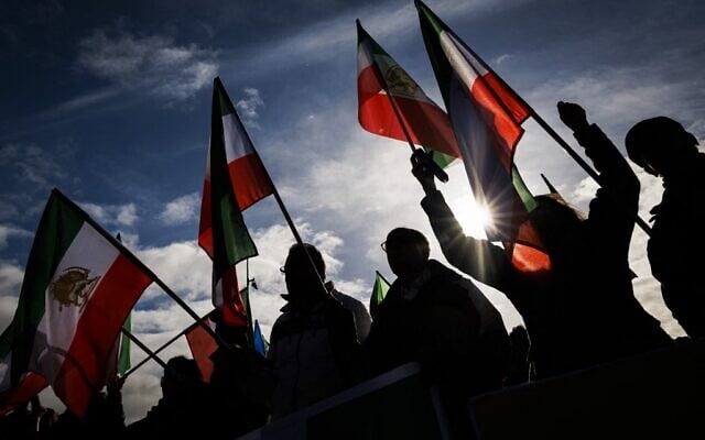 Protestors wave Iranian pre-Islamic revolution flags in front of the United Nations headquarters as they attend a rally amid a special session of the UN Human Rights Council on the situation in Iran, in Geneva on November 24, 2022. (VALENTIN FLAURAUD / AFP) Protestors wave Iranian pre-Islamic revolution flags in front of the United Nations headquarters as they attend a rally amid a special session of the UN Human Rights Council on the situation in Iran, in Geneva on November 24, 2022. (VALENTIN FLAURAUD / AFP)