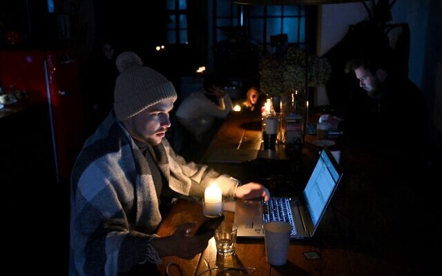 People sit in a coffee shop in Lviv as the city experiences a scheduled power outage on November 24, 2022. (Yuriy Dyachyshyn / AFP) People sit in a coffee shop in Lviv as the city experiences a scheduled power outage on November 24, 2022. (Yuriy Dyachyshyn / AFP)