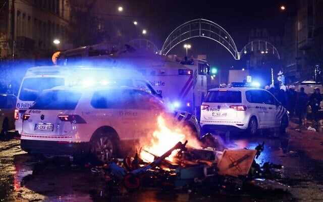 Police cars drive past burning electric scooters on the sideline of the live broadcast of the Qatar 2022 World Cup Group F football match between Belgium and Morocco, in Brussels, on November 27, 2022. (Kenzo TRIBOUILLARD / AFP) Police cars drive past burning electric scooters on the sideline of the live broadcast of the Qatar 2022 World Cup Group F football match between Belgium and Morocco, in Brussels, on November 27, 2022. (Kenzo TRIBOUILLARD / AFP)