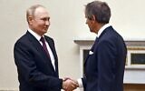 Russian President Vladimir Putin, left, and International Atomic Energy Agency (IAEA) Director General Rafael Mariano Grossi greet each other during their meeting in St. Petersburg, Russia, October 11, 2022. (Pavel Bednyakov, Sputnik, Kremlin Pool Photo via AP)