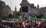 People wave pre-Islamic revolution Iran's flags and banners as they take part in a protest against Iranian authorities, in London, October 29, 2022. (AP Photo/Alberto Pezzali)