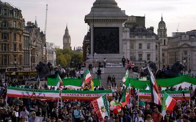 People wave pre-Islamic revolution Iran's flags and banners as they take part in a protest against Iranian authorities, in London, October 29, 2022. (AP Photo/Alberto Pezzali)