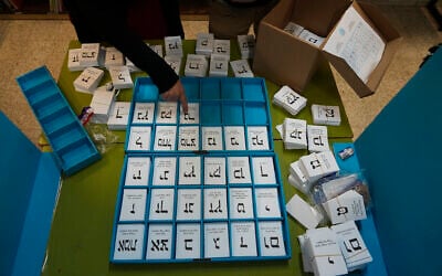 Electoral official arrange ballots in the West Bank settlement of Kiryat Arba during Israeli elections, Tuesday, Nov. 1, 2022. (AP Photo/Tsafrir Abayov)