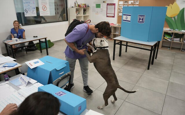 A man kisses his dog after voting in the Knesset elections, in Tel Aviv on November 1, 2022. (AP Photo/Ariel Schalit) A man kisses his dog after voting in the Knesset elections, in Tel Aviv on November 1, 2022. (AP Photo/Ariel Schalit)
