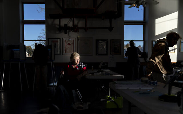 Supervisor Lou-Ann LaPorte looks on as a voter leaves the Aspray Boat House polling site after casting a ballot in the US midterm election in Warwick, Rhode Island, November 8, 2022. (AP Photo/David Goldman)