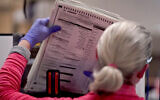 An election worker removes tabulated ballots to be boxed inside the Maricopa County Recorders Office, Wednesday, Nov. 9, 2022, in Phoenix. (AP/Matt York)