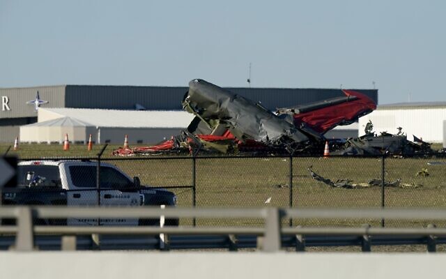 An emergency vehicle near debris from two US military planes that crashed during an airshow at Dallas Executive Airport, November 12, 2022. (AP Photo/LM Otero)