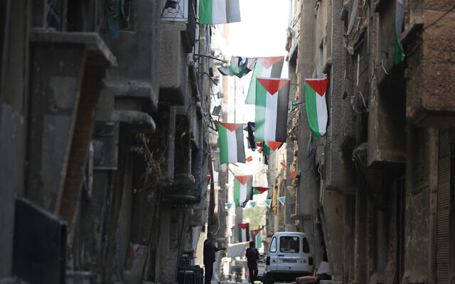 People walk under Palestinian flags in Yarmouk camp in Damascus Syria that has seen heavy fighting during the civil war, Nov. 2, 2022. (AP Photo/Omar Sanadiki, File) People walk under Palestinian flags in Yarmouk camp in Damascus Syria that has seen heavy fighting during the civil war, Nov. 2, 2022. (AP Photo/Omar Sanadiki, File)