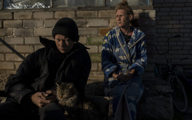 Vitaliy Mysharskiy, 14, left, and his grandmother Tanya Babii sit in the yard of the family house in the recently liberated village of Kyselivka, outskirts of Kherson, southern Ukraine, Nov. 15, 2022. (AP Photo/Bernat Armangue) Vitaliy Mysharskiy, 14, left, and his grandmother Tanya Babii sit in the yard of the family house in the recently liberated village of Kyselivka, outskirts of Kherson, southern Ukraine, Nov. 15, 2022. (AP Photo/Bernat Armangue)