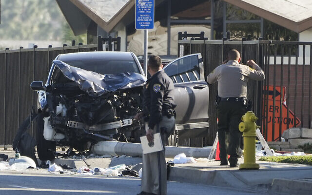 Two investigators stand next to a mangled SUV that struck Los Angeles County sheriff's recruits in Whittier, California, November 16, 2022. (Jae C. Hong/AP) Two investigators stand next to a mangled SUV that struck Los Angeles County sheriff's recruits in Whittier, California, November 16, 2022. (Jae C. Hong/AP)