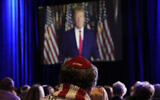 People listen as former US President Donald Trump speaks remotely to an annual leadership meeting of the Republican Jewish Coalition November 19, 2022, in Las Vegas. (AP Photo/John Locher)