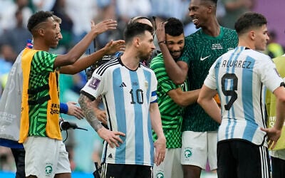 Argentina's Lionel Messi standing beside Saudi Arabia's players celebrating after winning the World Cup group C soccer match between Argentina and Saudi Arabia at the Lusail Stadium in Lusail, Qatar, November 22, 2022. (AP Photo/Natacha Pisarenko)