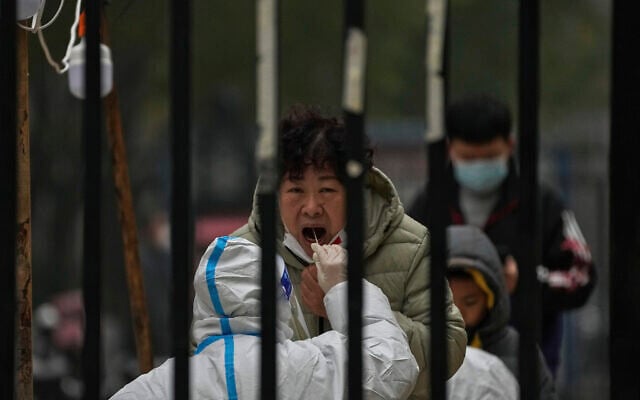 A woman has her routine COVID-19 test at a coronavirus testing site setup inside a residential compound in Beijing, Thursday, Nov. 24, 2022. (AP/Andy Wong) A woman has her routine COVID-19 test at a coronavirus testing site setup inside a residential compound in Beijing, Thursday, Nov. 24, 2022. (AP/Andy Wong)