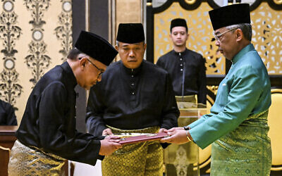 Malaysia's King Sultan Abdullah Sultan Ahmad Shah, right, and newly appointed Prime Minister Anwar Ibrahim, left, take part in the swearing-in ceremony at the National Palace in Kuala Lumpur, Malaysia, November 24, 2022. (Mohd Rasfan/Pool Photo via AP)