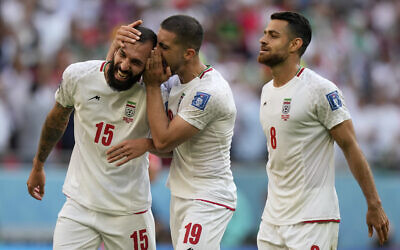 Iran's Majid Hosseini, from right, Iran's Morteza Pouraliganji and Iran's scorer Rouzbeh Cheshmihe celebrate after winning the World Cup group B soccer match between Wales and Iran, at the Ahmad Bin Ali Stadium in Al Rayyan, Qatar, November 25, 2022. (AP/Frank Augstein)