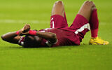Qatar's Ismail Mohamad lies after his side's 1-3 lost against Senegal during a World Cup group A soccer match at the Al Thumama Stadium in Doha, Qatar, Friday, Nov. 25, 2022. (AP/Petr Josek)
