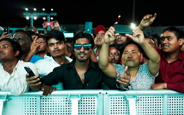 Migrant workers cheer at a fan festival at the Asian Town cricket stadium in Doha, Qatar, November 25, 2022. (AP/Jon Gambrell) Migrant workers cheer at a fan festival at the Asian Town cricket stadium in Doha, Qatar, November 25, 2022. (AP/Jon Gambrell)