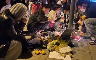 Residents mourn for the victims of a recent deadly fire at a residential building in Urumqi city in Shanghai, China Saturday, Nov. 26, 2022. (Chinatopix Via AP)