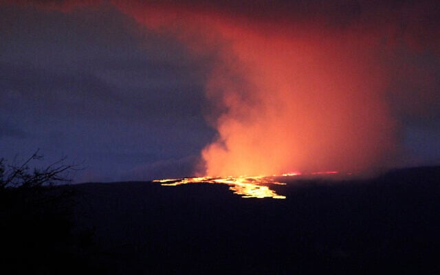 Lava pours out of the summit crater of Mauna Loa about 6:35 a.m. Monday, Nov. 28, 2022, as seen from Gilbert Kahele Recreation Area on Maunakea, Hawaii. Mauna Loa, the world’s largest active volcano, began spewing ash and debris from its summit, prompting civil defense officials to warn residents on Monday to prepare in case the eruption causes lava to flow toward communities. (Chelsea Jensen/West Hawaii Today via AP) Lava pours out of the summit crater of Mauna Loa about 6:35 a.m. Monday, Nov. 28, 2022, as seen from Gilbert Kahele Recreation Area on Maunakea, Hawaii. Mauna Loa, the world’s largest active volcano, began spewing ash and debris from its summit, prompting civil defense officials to warn residents on Monday to prepare in case the eruption causes lava to flow toward communities. (Chelsea Jensen/West Hawaii Today via AP)