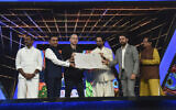 Israeli filmmaker and jury chair Nadav Lapid, third left, being honored by Indian ministers at the closing ceremony of the International Film Festival of India in Goa, India, Nov.28, 2022. (Press Information Bureau via AP)