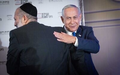 Head of the Likud party Benjamin Netanyahu, right, with Shas chair Aryeh Deri at a conference in Jerusalem on September 12, 2022. (Yonatan Sindel/Flash90)