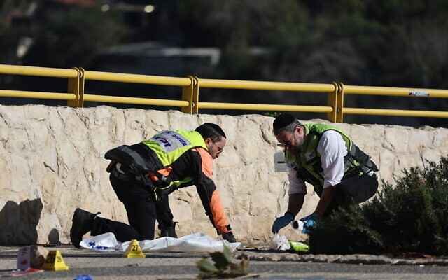 ZAKA personnel clean blood off the ground at the scene of an explosion near the entrance to Jerusalem, on November 23, 2022 (Yonatan Sindel/Flash90) ZAKA personnel clean blood off the ground at the scene of an explosion near the entrance to Jerusalem, on November 23, 2022 (Yonatan Sindel/Flash90)