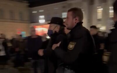 Munich interfaith commissioner Marian Offman is forced to a police van by an officer, November 9, 2022 (screenshot)