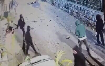 Screen capture from video shows Muhammad Zahran, left, falling to the ground after allegedly being hit by one of a mob of Jewish Israelis in Jerusalem's Sheikh Jarrah neighborhood, on October 31, 2022. (Twitter. Used in accordance with Clause 27a of the Copyright Law)
