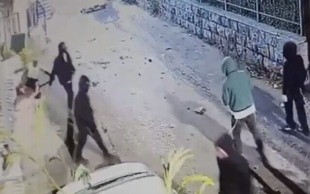 Screen capture from video shows Muhammad Zahran, left, falling to the ground after allegedly being hit by one of a mob of Jewish Israelis in Jerusalem's Sheikh Jarrah neighborhood, on October 31, 2022. (Twitter. Used in accordance with Clause 27a of the Copyright Law) Screen capture from video shows Muhammad Zahran, left, falling to the ground after allegedly being hit by one of a mob of Jewish Israelis in Jerusalem's Sheikh Jarrah neighborhood, on October 31, 2022. (Twitter. Used in accordance with Clause 27a of the Copyright Law)