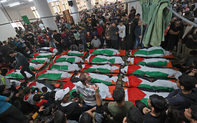 Palestinians carry the bodies of people who died when fire broke out in an apartment, in the Jabalia camp in the northern Gaza strip, on November 18, 2022. (Said Khatib/AFP)