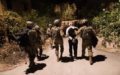 Israeli troops arrest a wanted Palestinian during a raid in the West Bank, early November 21, 2022. (Israel Defense Forces)