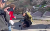 An Israeli soldier is seen punching a left-wing activist in Hebron in the West Bank, November 25, 2022. (Breaking the Silence)
