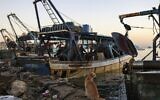 A cat waits to eat a fish on a boat the port in Gaza City early on December 1, 2022. (RONALDO SCHEMIDT / AFP)