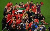 Morocco's players celebrate with a Palestinian flag at the end of the Qatar 2022 World Cup round of 16 football match between Morocco and Spain at the Education City Stadium in Al-Rayyan, west of Doha, on December 6, 2022. (Glyn KIRK / AFP)