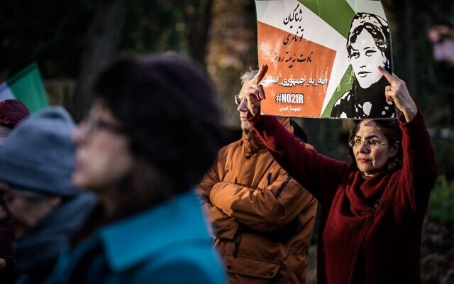 A protestor holds a slogan in Persian reading, 'No to Islamic Republic' and another slogan in Kurdish reading, 'Jina (Mahsa Amini), dear! You will not die, Your name will turn into a symbol' during a demonstration in front of the House of Representatives in The Hague, on December 7, 2022. (Bart Maat / ANP / AFP) A protestor holds a slogan in Persian reading, 'No to Islamic Republic' and another slogan in Kurdish reading, 'Jina (Mahsa Amini), dear! You will not die, Your name will turn into a symbol' during a demonstration in front of the House of Representatives in The Hague, on December 7, 2022. (Bart Maat / ANP / AFP)