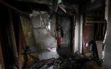 File --  Maryna, 59, stands outside the door of her neighbors' damaged flat in a multi-story residential building following Russian strike in the southern Ukrainian town of Kherson on December 7, 2022 (ANATOLII STEPANOV/AFP)