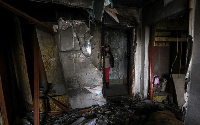 File --  Maryna, 59, stands outside the door of her neighbors' damaged flat in a multi-story residential building following Russian strike in the southern Ukrainian town of Kherson on December 7, 2022 (ANATOLII STEPANOV/AFP)