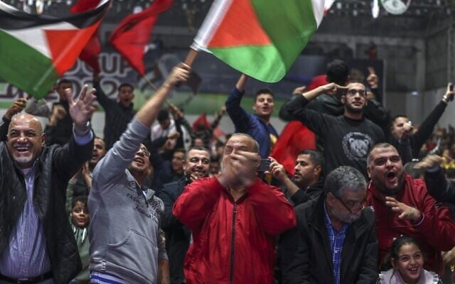 Palestinian football fans lift national and Moroccan flags as they celebrate Morocco's win of the Qatar 2022 World Cup round 16 soccer match against Portugal in Gaza City, on December 10, 2022. (MOHAMMED ABED / AFP)