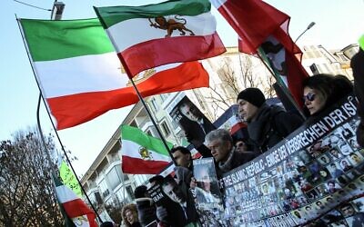 Protesters wave the Lion and Sun flag as they take part in a protest in front of the Iranian consulate in Frankfurt am Main, on December 16, 2022. (Daniel Roland/AFP)