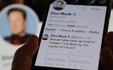 A phone displaying Elon Musk's Twitter page, where the billionaire conducted a platform-based survey about his future as the head of the company, December 18, 2022. (Chris DELMAS/AFP)
