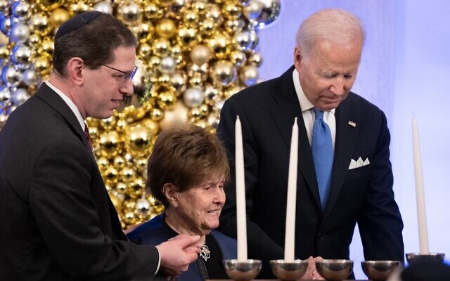Rabbi Charlie Cytron-Walker and US President Joe Biden help Holocaust survivor Bronia Brandman to a menorah during a Hanukkah reception at the White House in Washington, December 19, 2022. (Brendan Smialowski/AFP) Rabbi Charlie Cytron-Walker and US President Joe Biden help Holocaust survivor Bronia Brandman to a menorah during a Hanukkah reception at the White House in Washington, December 19, 2022. (Brendan Smialowski/AFP)