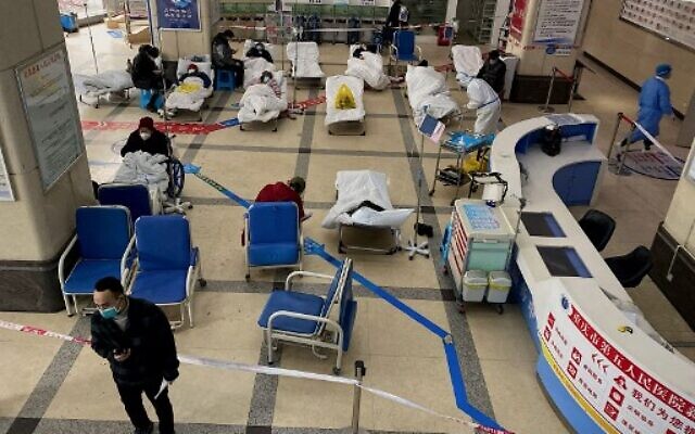 A man stands in front of a cordoned-off area, where COVID-19 patients lie on hospital beds, in the lobby of the Chongqing No. 5 People's Hospital in China's southwestern city of Chongqing on December 23, 2022. (Noel Celis/AFP) A man stands in front of a cordoned-off area, where COVID-19 patients lie on hospital beds, in the lobby of the Chongqing No. 5 People's Hospital in China's southwestern city of Chongqing on December 23, 2022. (Noel Celis/AFP)