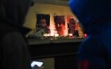 This photograph taken on December 24, 2022, shows tribute candles and pictures of three victims of a shooting on December 23, 2022, Mir Perwer (L), Emine Kara and Abdurrahman Kizil, in front of the "Centre democratique du Kurdistan" (Kurdistan democratic center) in Paris (Julie SEBADELHA / AFP)