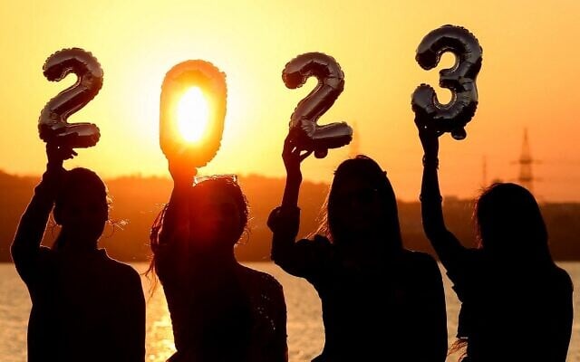 Women are silhouetted against the setting sun as they hold up numeric shaped balloons on the eve of New Year in Bhopal, India, on December 31, 2022. (Gagan Nayar/AFP) Women are silhouetted against the setting sun as they hold up numeric shaped balloons on the eve of New Year in Bhopal, India, on December 31, 2022. (Gagan Nayar/AFP)