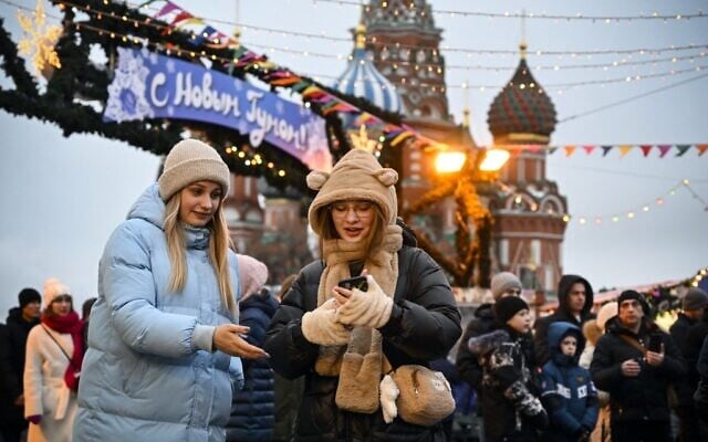 People walk along the Red Square in front of the St. Basil's Cathedral in Moscow on December 31, 2022. (Alexander Nemenov/AFP)