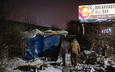 An outreach worker delivers supplies to people living in a homeless camp on December 23, 2022 in Louisville, Kentucky. (Jon Cherry/Getty Images North America/Getty Images via AFP)