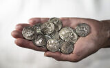 2,200-year-old silver coins that were discovered in a wooden box inside a cave in Wadi Muraba‘at near the Dead Sea. (Shai Halevy, Israel Antiquities Authority)