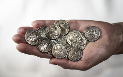 2,200-year-old silver coins that were discovered in a wooden box inside a cave in Wadi Muraba‘at near the Dead Sea. (Shai Halevy, Israel Antiquities Authority)