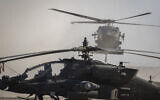 Illustrative: A Blackhawk helicopter lands next to an Apache attack helicopter at a US military base at undisclosed location in Eastern Syria, November 11, 2019. (Darko Bandic/AP)